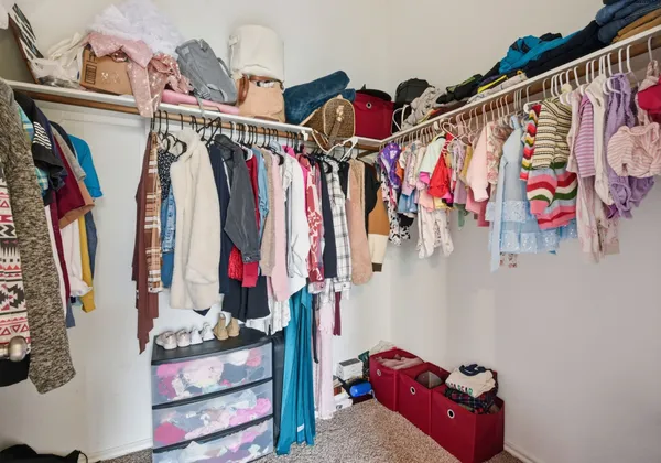 a view of walk in closet with clothes