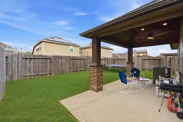 a view of a chair and table in backyard of the house