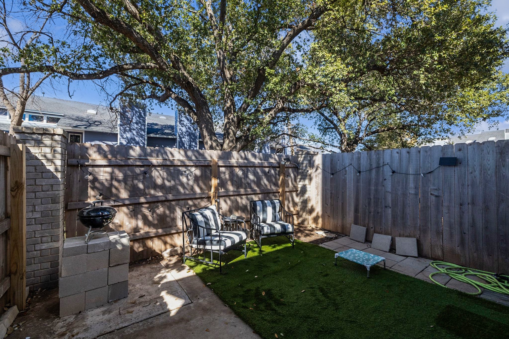 1010 West Rundberg Lane, Unit 30 Austin, TX 78758 - Photo 17 of 30 a view of backyard with large tree and wooden fence