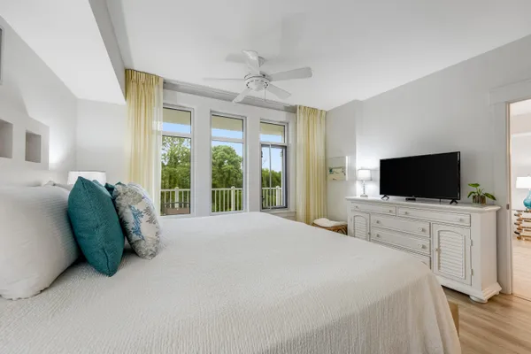 a spacious bedroom with a bed and a flat screen tv