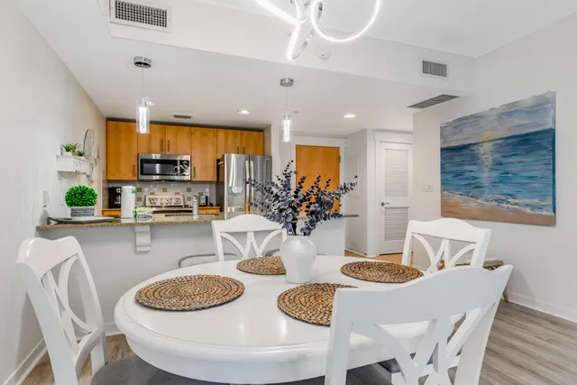 a kitchen with stainless steel appliances a dining table and chairs