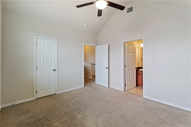 an empty room with windows and fan