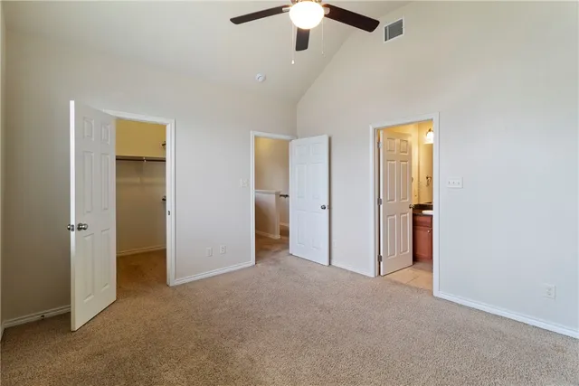 an empty room with closet and a ceiling fan