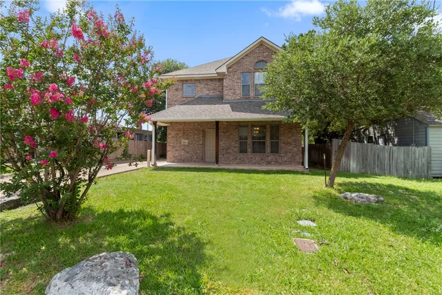a front view of a house with a garden