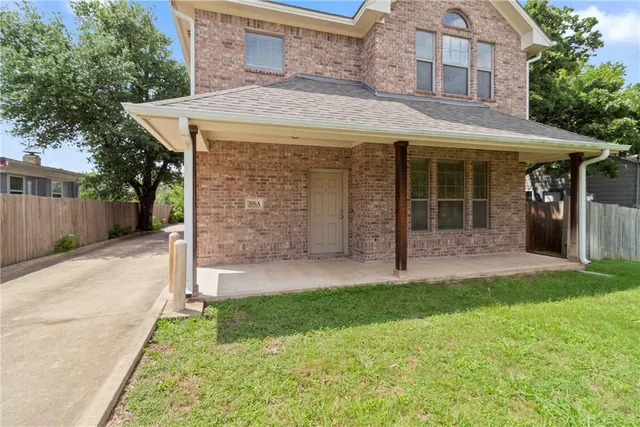 a view of a house with a yard and tree