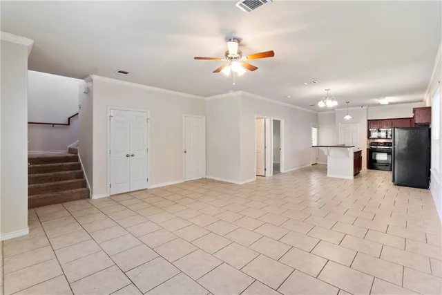a view of an empty room and kitchen view
