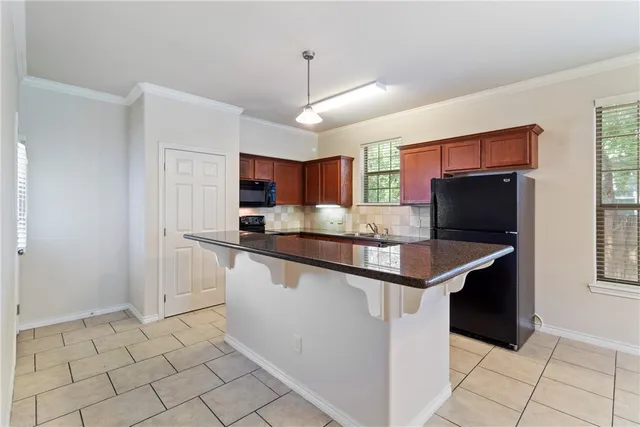 a kitchen with stainless steel appliances granite countertop a sink and a refrigerator