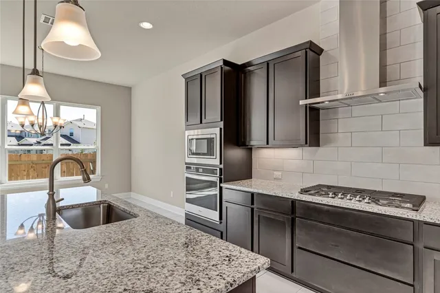 a kitchen with stainless steel appliances granite countertop a sink stove and refrigerator