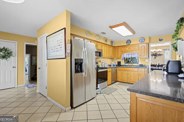 a kitchen with granite countertop a refrigerator and a stove top oven