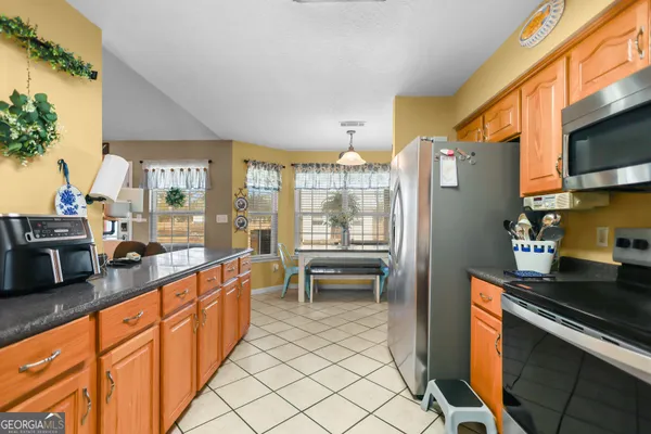 a kitchen with stainless steel appliances granite countertop a stove a sink a microwave and a refrigerator