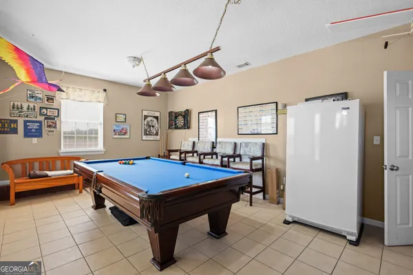 a room with furniture pool table and windows