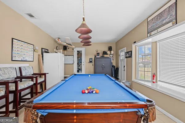 a room with pool table and windows