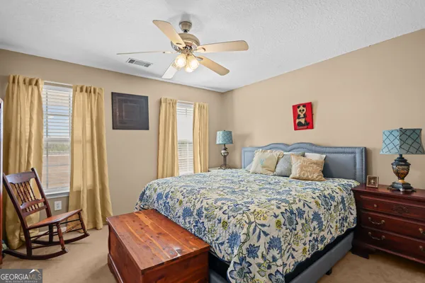 a bedroom with a bed dresser and a window