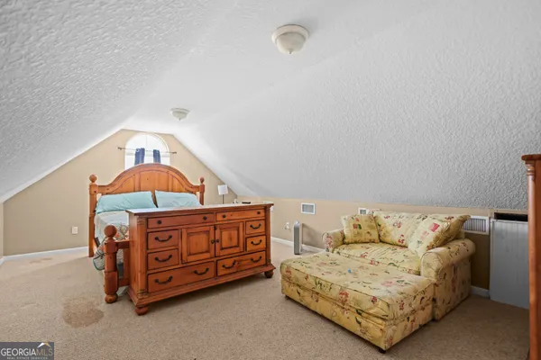 a bedroom with a bed and a lamp with the view of a small space