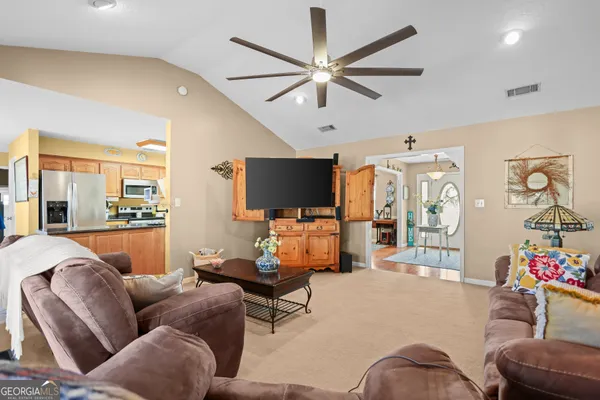 a living room with furniture a large window and a chandelier