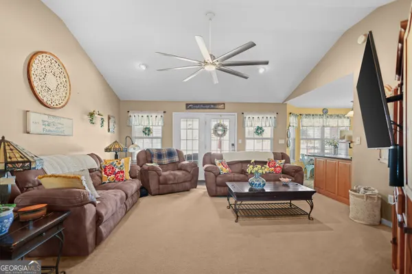 a living room with furniture a clock and a flat screen tv