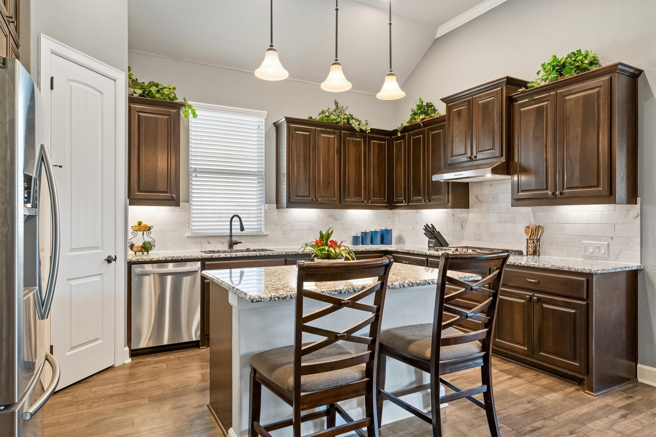 1004 Hezekiah Lane Leander, TX 78641 - Photo 11 of 36 a kitchen with stainless steel appliances granite countertop a stove a sink dishwasher a refrigerator with a dining table and chairs