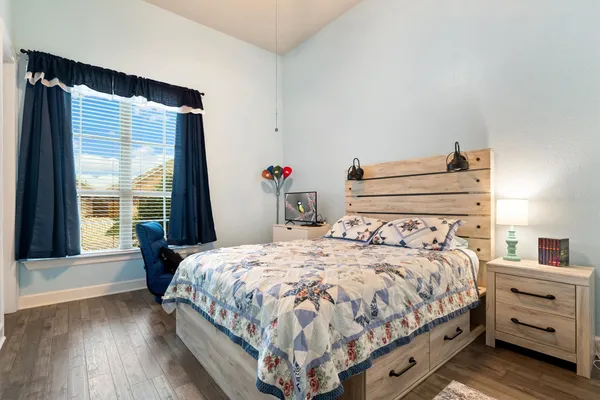 a bedroom with a bed and wooden floor