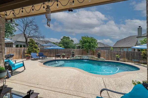 an outdoor space with swimming pool and furniture