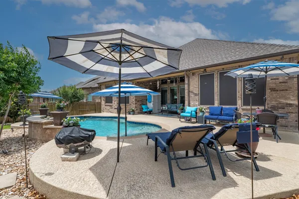 a view of a patio with a table and chairs under an umbrella