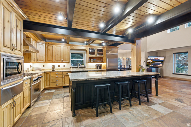 8650 Redden Road Park City, UT 84098 - Photo 9 of 71 Kitchen featuring a large island, stainless steel appliances, wood cabinetry, and a wood plank ceiling with exposed beams