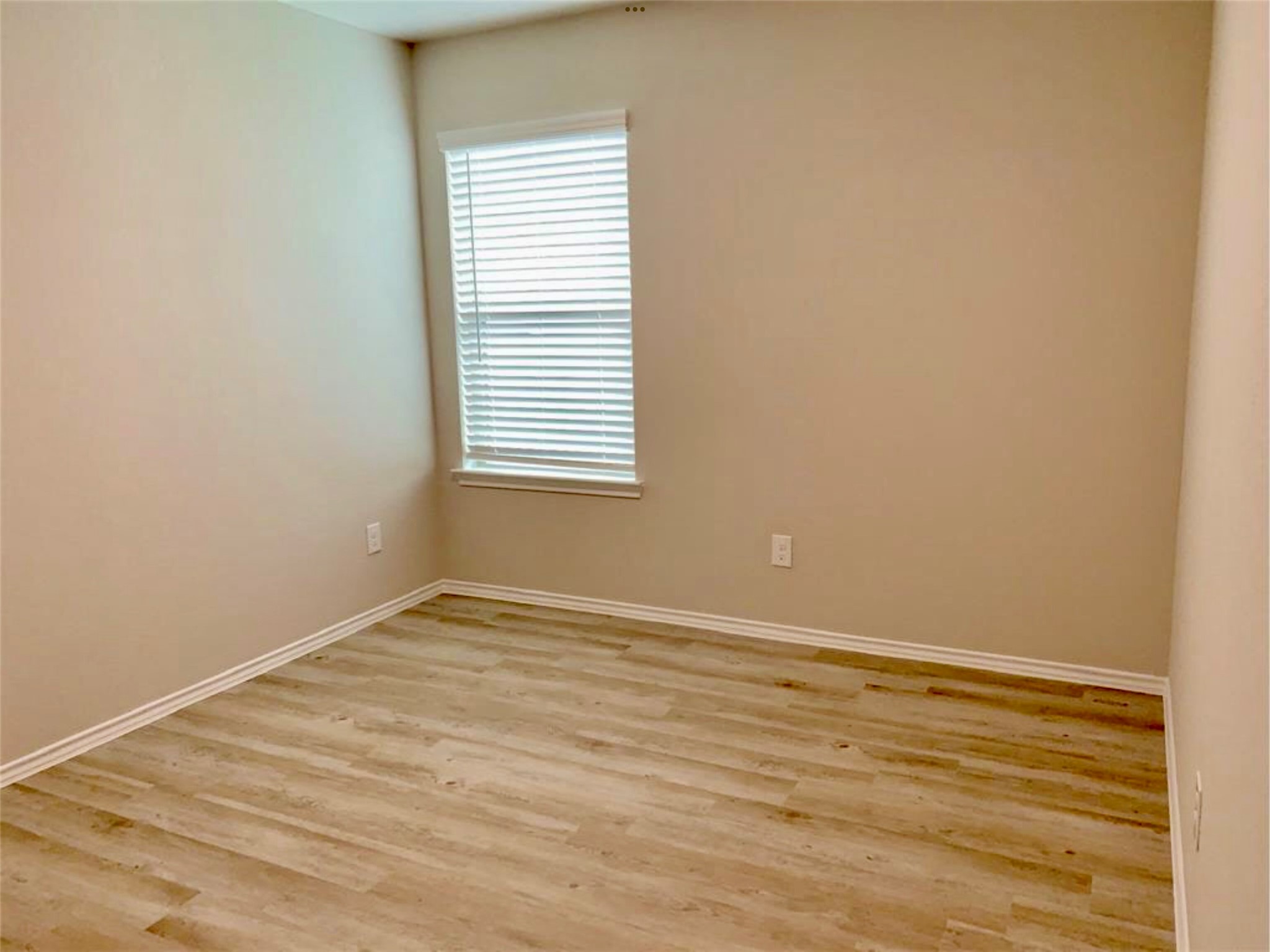 2203 Levant Lane Baytown, TX 77523 - Photo 14 of 17 a view of an empty room with wooden floor and a window