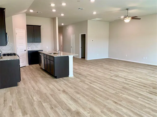 a kitchen with stainless steel appliances a large counter top a stove and a refrigerator