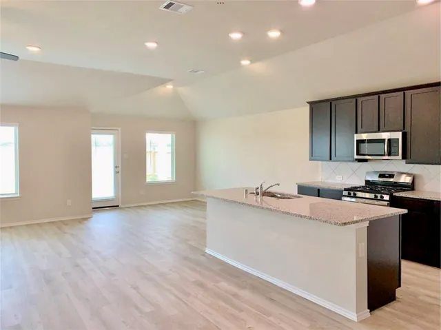 a kitchen with granite countertop a sink and cabinets