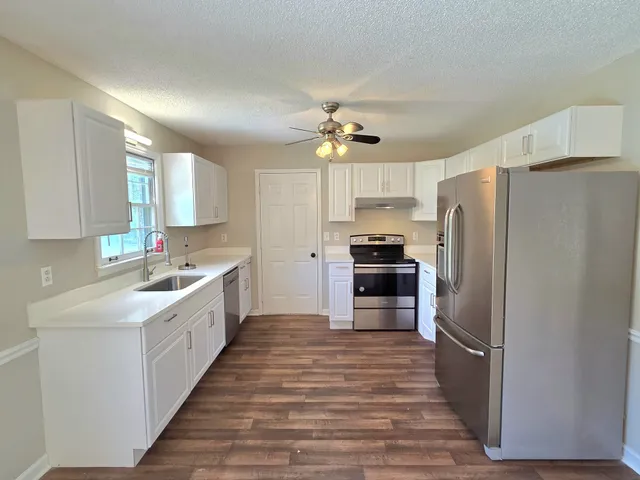 a kitchen with stainless steel appliances a refrigerator sink and cabinets