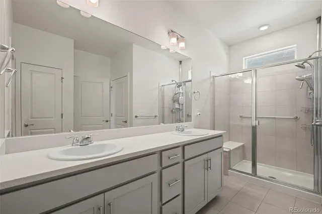a bathroom with a sink double vanity granite tub shower and a mirror