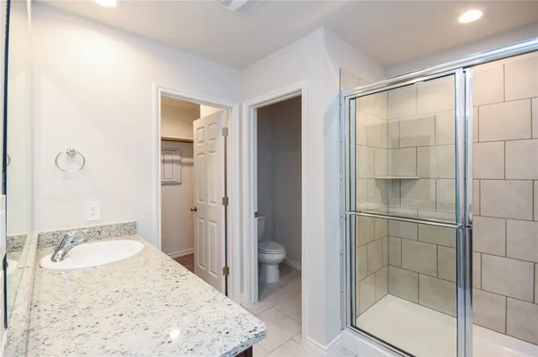 a bathroom with a granite countertop shower a mirror and a sink