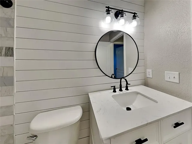 a bathroom with a toilet a sink and mirror