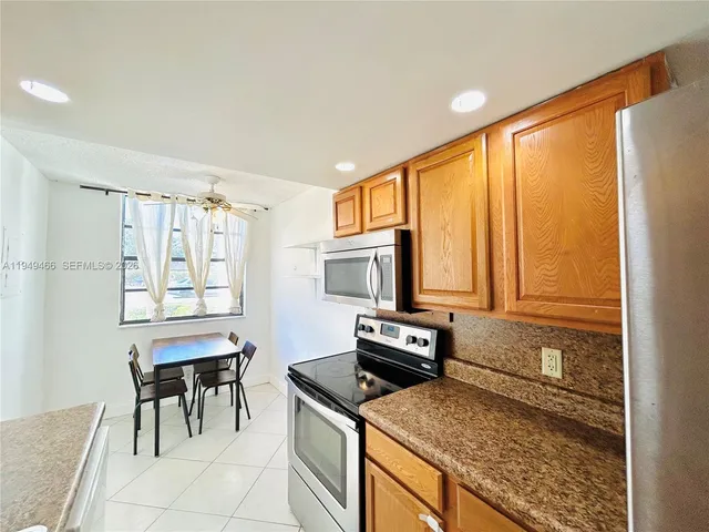 a kitchen with granite countertop a stove top oven microwave and cabinets