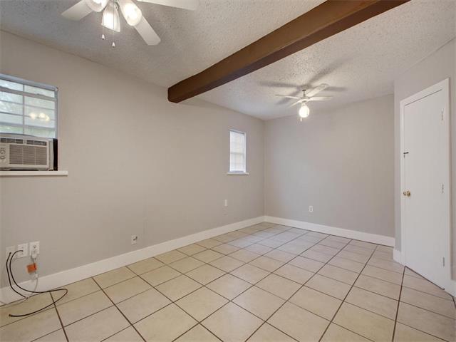 605 Elmwood Place, Unit B Austin, TX 78705 - Photo 5 of 10 an empty room with windows and fan