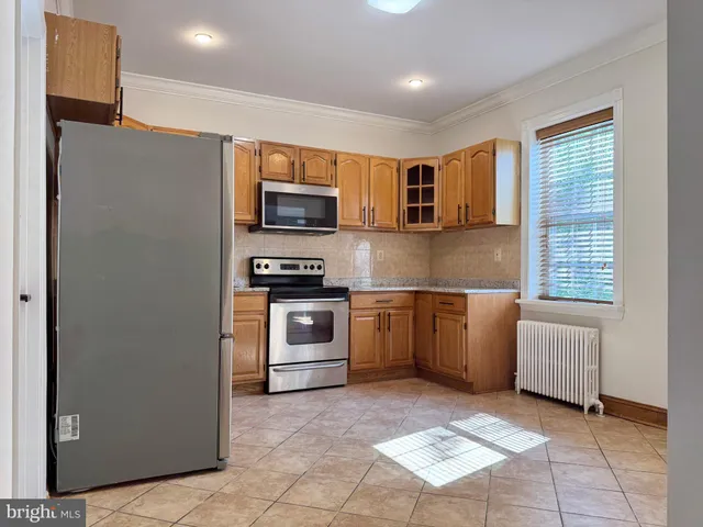 a kitchen with stainless steel appliances granite countertop a refrigerator and a stove top oven