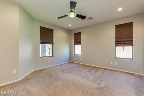 an empty room with a ceiling fan and a window