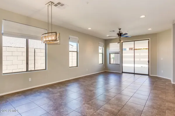 a view of an empty room with a window and chandelier