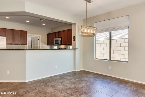 a kitchen with stainless steel appliances granite countertop a refrigerator a stove a sink and a chandelier