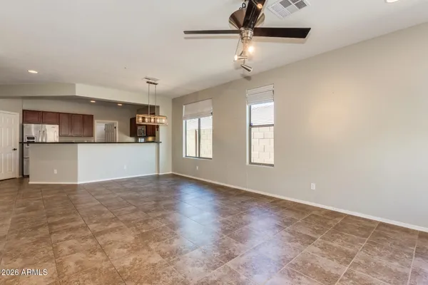 a kitchen with stainless steel appliances granite countertop a stove a sink a refrigerator a granite counter space and large windows