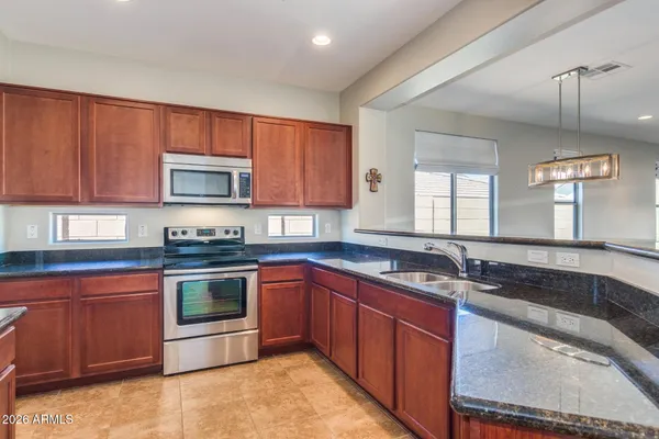 a kitchen with stainless steel appliances granite countertop a refrigerator and a sink