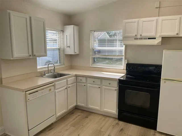 a kitchen with cabinets appliances a sink and a window