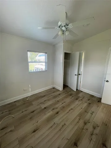 a view of empty room with window and wooden floor
