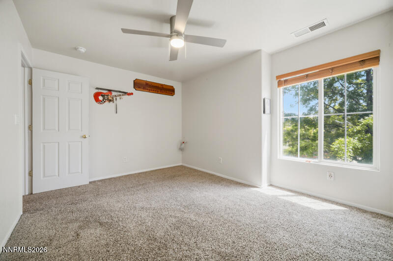 7873 Welsh Drive Reno, NV 89506 - Photo 25 of 34 an empty room with a ceiling fan and windows