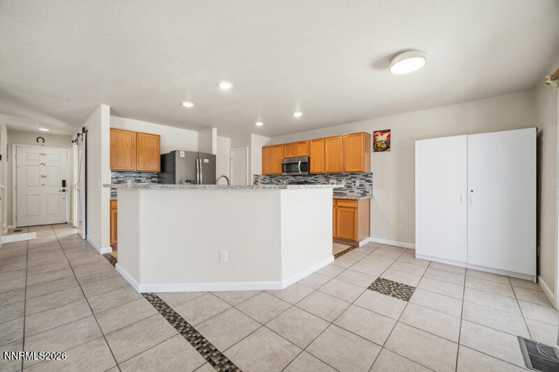 7873 Welsh Drive Reno, NV 89506 - Photo 7 of 34 a kitchen with stainless steel appliances granite countertop a refrigerator and a stove top oven