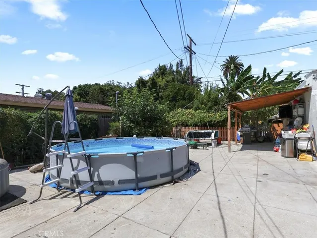 a view of a patio with dining table and chairs under an umbrella