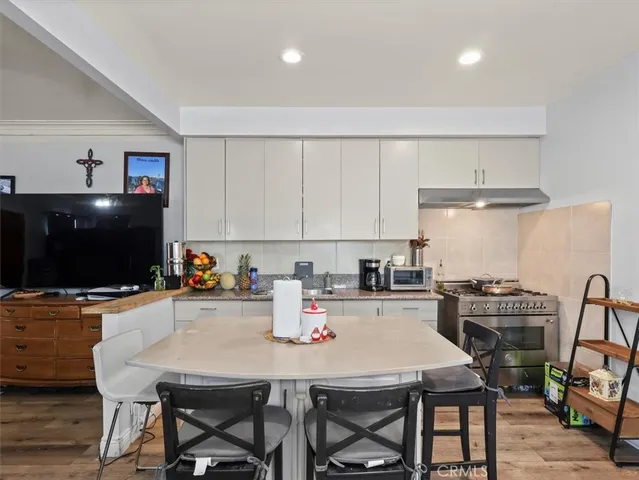 a kitchen with a stove a microwave a dining table and chairs