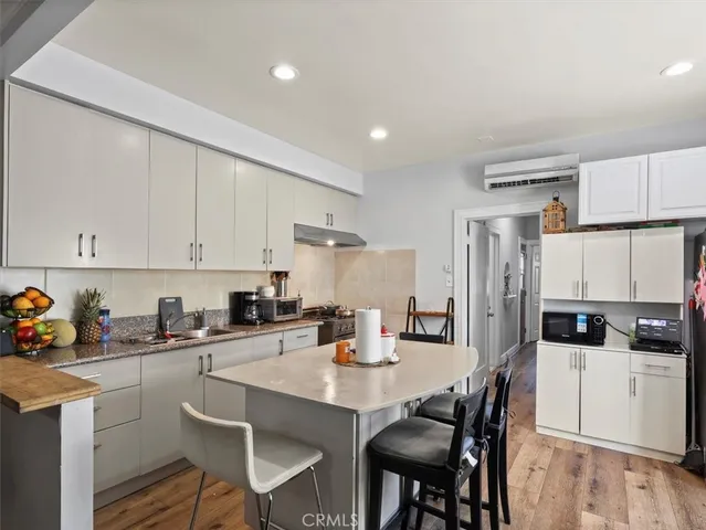 a kitchen with stainless steel appliances a sink a stove a refrigerator cabinets and dining table