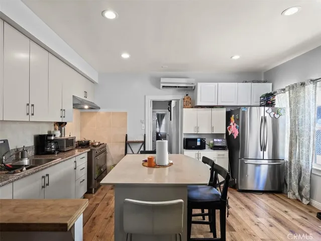 a kitchen with refrigerator a sink and chairs