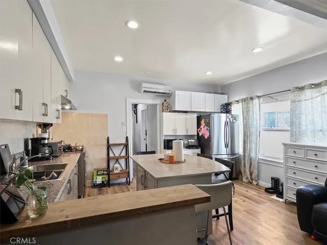 a kitchen with stainless steel appliances granite countertop sink refrigerator and cabinets