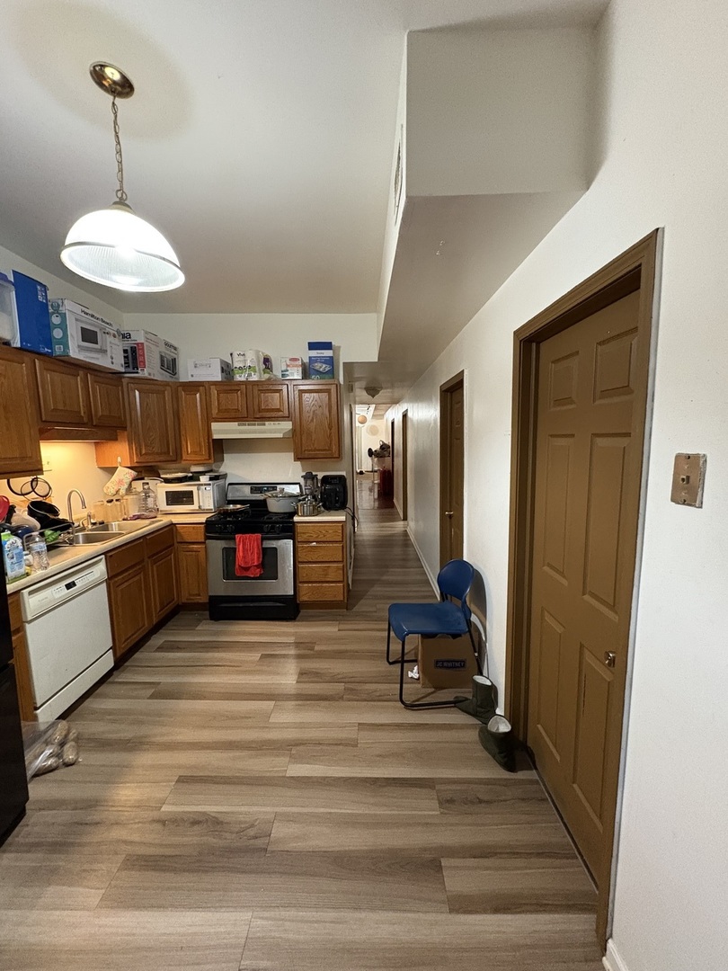 8729 South Commercial Avenue Chicago, IL 60617 - Photo 4 of 17 a large kitchen with stainless steel appliances granite countertop a stove and cabinets